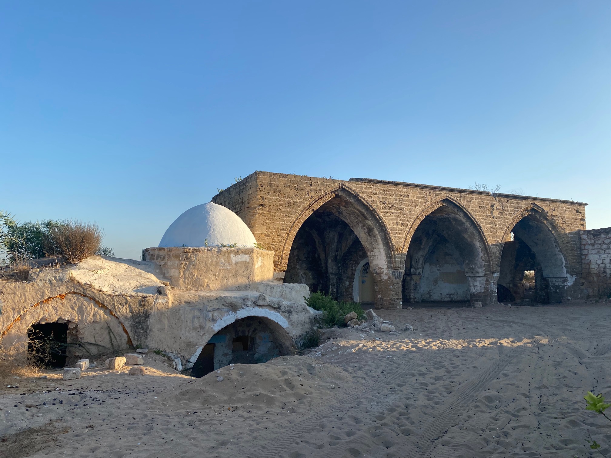 Túmulo tradicional de Rúben em Palmachim (Nabi Rubin), Israel, com cúpula branca e arcadas de pedra ao fundo.