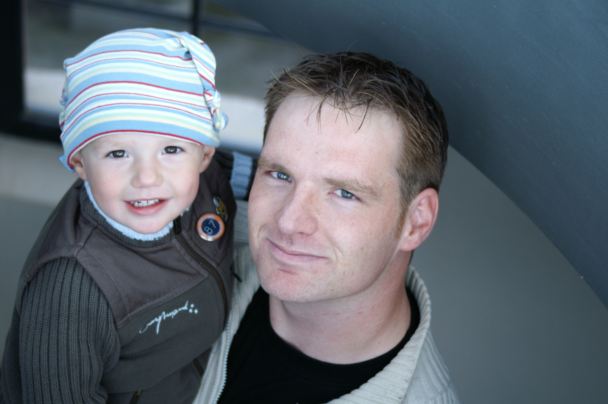 Pai e filho pequeno fotografados juntos, representando laços familiares entre homens de gerações diferentes.